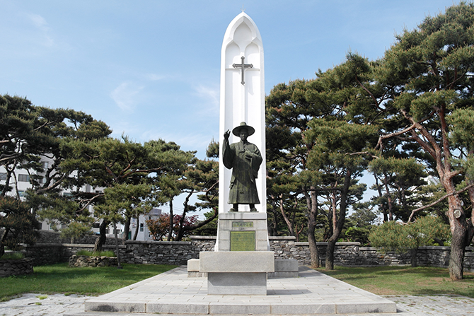 소나무 숲에 자리한 성 김대건 안드레아 신부 동상. - 고기은 제공