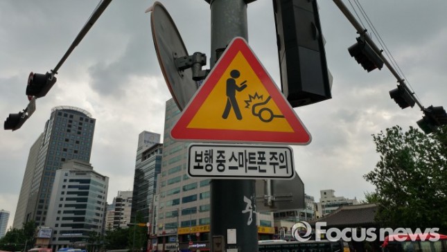 서울시와 경찰청은 보행 중 스마트폰 사용으로 인한 사고를 줄이기 위해 16일부터 홍대 앞 등 5곳에 보행 중 스마트폰 사용의 위험을 인지시키는 내용을 담은 교통안전표지과 보도부착물을 설치했다. - 서울시청 제공