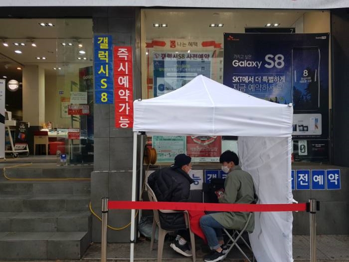 서울 종로구 SK텔레콤 T월드 카페 앞에서 두 명의 고객이 갤럭시S8 개통을 기다리고 있다. - 포커스뉴스 제공