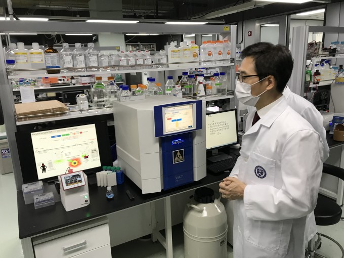 천진우 기초과학연구원(IBS) 나노의학 연구단 단장이 직접 개발한 나노 PCR 진단 기기(모니터 앞)에 대해 설명하고 있다. 오른쪽에 보이는 커다란 기기가 기존에 쓰는 RT-PCR 기기다. 김우현(mnchoo@donga.com)