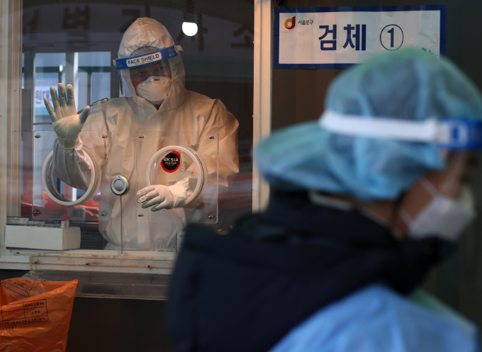 설날인 12일 오전 서울역에 설치된 중구임시선별진료소에서 의료진이 검체 대기자를 향해 손을 들어보이고 있다. 연합뉴스