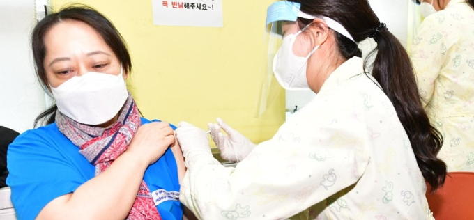 신종 코로나바이러스 감염증(코로나19) 백신 접종이 시작된 26일 오전 광명시보건소 접종실에서 첫 접종자인 강경희(52) 씨가 백신 주사를 맞고 있다. 연합뉴스 제공