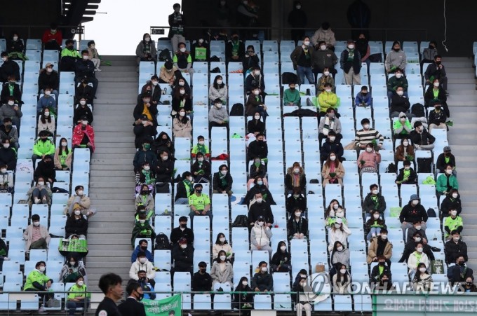 지난달 27일 전주월드컵경기장에서 열린 K리그1 전북 현대와 FC서울의 개막전에서 팬들이 사회적 거리두기를 한 채 경기를 관람하고 있다. 연합뉴스 제공