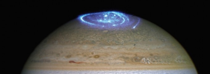 어두운 지구 극지방과 달리 오로라가 밝게 빛나는 목성 극지방의 모습. NASA 제공