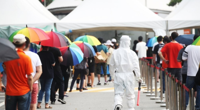 산업단지에 내려진 근로자에 진단검사 행정명령으로 29일 오전 경기도 안산시 단원구 외국인주민지원본부 옆에 설치된 신종 코로나바이러스 감염증(코로나19) 임시선별검사소에 시민들이 길게 줄을 서 있다. 연합뉴스 제공