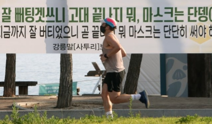 최근 강원 강릉지역에서 코로나19 확진자가 연일 두 자릿수로 쏟아지고 있는 가운데 30일 오전 한 해변에 강릉 사투리로 된 현수막이 걸려 있다. 연합뉴스 제공