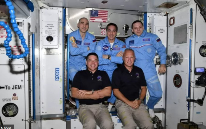 SpaceXの最初の民間宇宙船であるクルードラゴンカプセルに乗った2人の宇宙飛行士（最前列）が、国際宇宙ステーション（ISS）のメンバーとポーズをとります。 