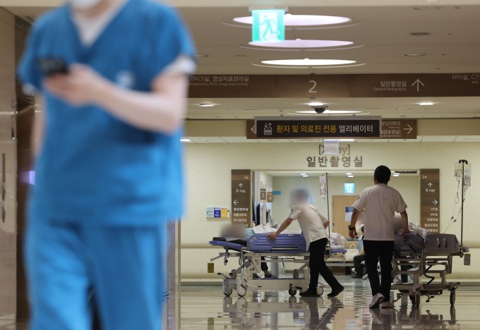 의대 증원 정책과 관련해 의정갈등이 계속되고 있는 19일 서울 시내 한 대학병원에서 의료 관계자와 환자들이 이동하고 있다. 연합뉴스 제공